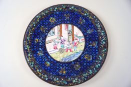 An early 20th century Canton enamel plate painted with figures in a garden, 18.