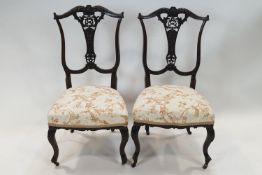 A pair of Edwardian mahogany nursing chairs with carved and pierced splats,