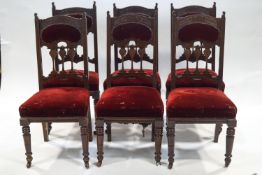 A set of six Edwardian mahogany dining chairs, carved in Art Nouveau style and upholstered in red,