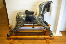 A 20th century painted dapple grey rocking horse with replacement mane and tail,