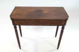 A Regency mahogany and boxwood strung card table on turned and fluted legs,
