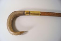 A horn handled walking stick with brass mounts