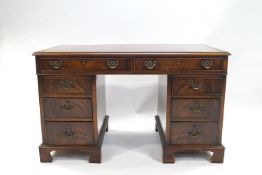 A mahogany pedestal desk with leather inset top above two drawers with three drawers to each