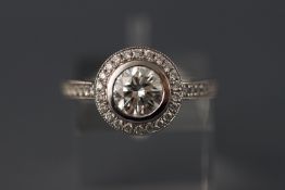 An 18ct white gold diamond halo style solitaire ring. Centre diamond 1.06ct. Halo mount 0.35ct.