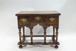 An early 18th century walnut veneered on composite carcass low boy with plain rectangular top over