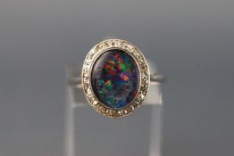 A white metal cluster ring set with an opal triplet and diamond surround. Stamped PLAT. Size O 3.