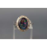 A white metal cluster ring set with an opal triplet and diamond surround. Stamped PLAT. Size O 3.