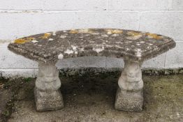 A re-constituted stone semi-circular garden seat on squirrel supports,