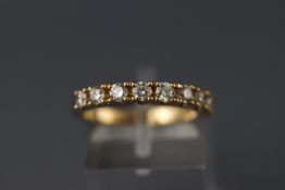 A yellow metal nine stone half hoop diamond ring. Stated weight of 0.75ct. Hallmarked 9ct gold.