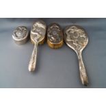 A Chinese white metal four piece dressing table set, each piece embossed with a dragon,