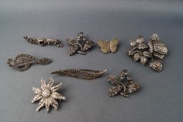 Eight white metal and marcasite brooches, of various designs, some stamped "silver" and "925",