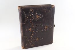 A Victorian leather bound photograph album, the cover embossed and gilded,