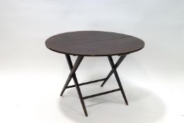 A stained beech coaching table with round folding top,