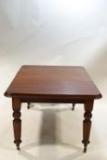 A Victorian mahogany extending dining table with single leaf on turned legs,