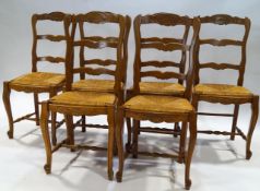 A set of six French chairs with shaped ladder backs on rush seats on cabriole legs joined by turned