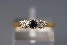 An 18ct three stone sapphire and diamond ring. Stamped 18ct. Size L 2.