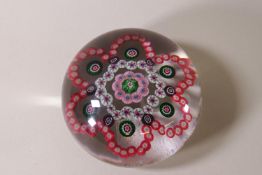 A 19th Century Baccharat glass paperweight with predominantly pink,