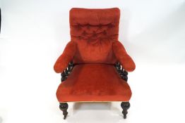 A Victorian red armchair with turned legs and baluster arms,