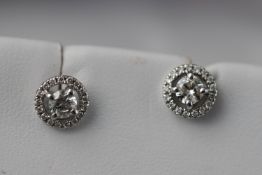 A white metal pair of diamond cluster earrings. Estimated total weight 0.50ct.