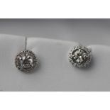 A white metal pair of diamond cluster earrings. Estimated total weight 0.50ct.