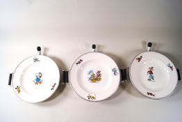 Three Walt Disney printed plate warmers, printed with Donald Duck and one with Goofy,