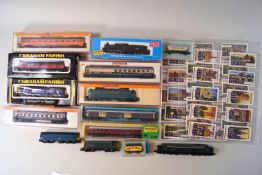 A collection of N-gauge model railway, comprising four Arnold coaches and rolling stock,