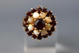 A yellow metal garnet and opal cluster ring. Hallmarked 9ct gold, Birmingham, 1975. Size: M 4.