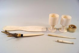 A 19th century French ivory shoe horn, dated 1865, a pair of ivory egg cups,