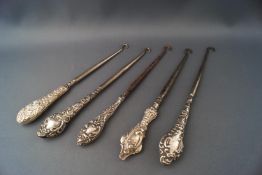 Five silver button hooks,