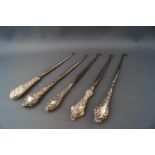 Five silver button hooks,