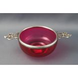 A cranberry glass and silver mounted quaiche, by William Comyns & Sons Ltd, 18cm diameter,