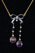 A yellow and white metal centrepiece necklace stylized as a drop bow and set with amethyst,