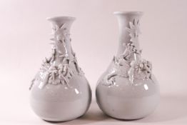 A pair of Chinese porcelain vases with applied models of dragons to the necks,