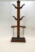 A Victorian mahogany hallstand with six hooks, above an umbrella stand,