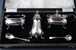 A pair of silver three piece cruets, both cased, the salt and mustard pots with blue glass liners,