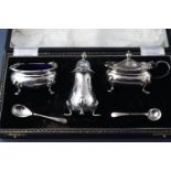 A pair of silver three piece cruets, both cased, the salt and mustard pots with blue glass liners,