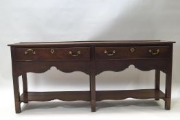A George III oak dresser base with two drawers above a shaped apron,
