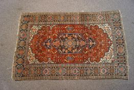 A Heriz rug with central medallion on a red field within one wide border,
