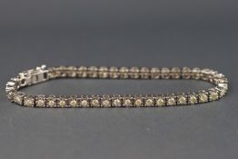 A white metal diamond line bracelet illusion set with forty five round brilliant cut diamonds,