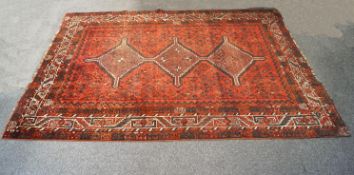 A Caucasian rug with three linked central medallions to a stylised plant patterned field within