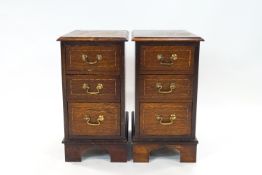 A pair of oak bedside chests of three drawers with mahogany tops, 61.