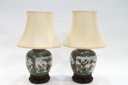 A pair of Chinese famille vert porcelain table lamps and shades on carved wood stands