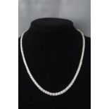 A white metal graduated diamond line necklace set with one hundred and twenty five round brilliant