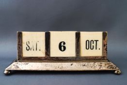 A silver mounted desk calendar, with flared base on four ball feet, with ivorine inserts,