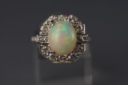 A white metal cluster ring set with an oval cabochon opal approx 11.0mm x 9.