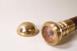 A novelty walking cane with brass compass knop and a glass phial inside
