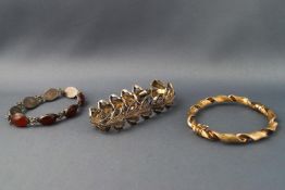 Two white metal bracelets, both stamped "925" and a gilt bangle also stamped "925",