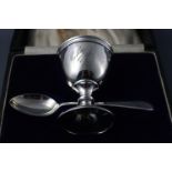 A silver christening egg cup and spoon, cased, both inscribed, London 1921,