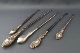 Five silver button hooks, of various designs and sizes, the largest being 28.