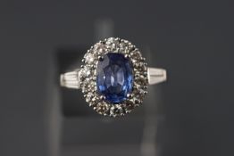 A white metal sapphire and diamond cluster ring. Sapphire approx 1.47ct.